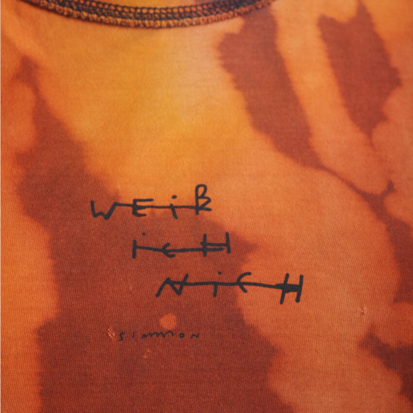 Alextravagant_T-Shirt-Weiss-ich-nich_orange-terra-schwarz-(M)_5 Upcycling T-Shirt aus Second Hand Merchandise mit Motiv "Weiß ich nich" von Künstler und Illustrator Simon Schirmer (Simmmon)