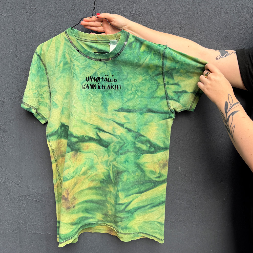 Alextravagant_T-Shirt-unauffaellig-kann-ich-nicht_limette-dunkelgruen-(M)_1 Upcycling T-Shirt aus Second Hand Merchandise mit Motiv "Unauffällig kann ich nicht" von Grafikerin Charleen Dröse (Rocketpennie)