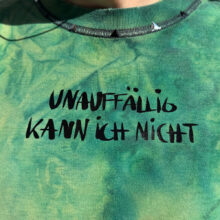 Alextravagant_T-Shirt-unauffaellig-kann-ich-nicht_limette-dunkelgruen-(M)_6 Upcycling T-Shirt aus Second Hand Merchandise mit Motiv "Unauffällig kann ich nicht" von Grafikerin Charleen Dröse (Rocketpennie)